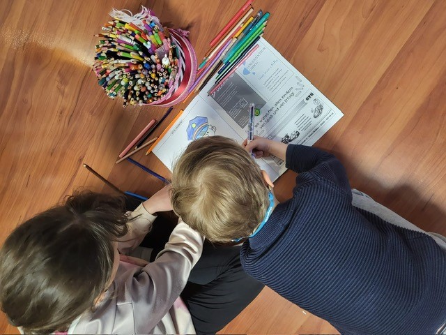 Zwei Kinder malen im Malbuch.