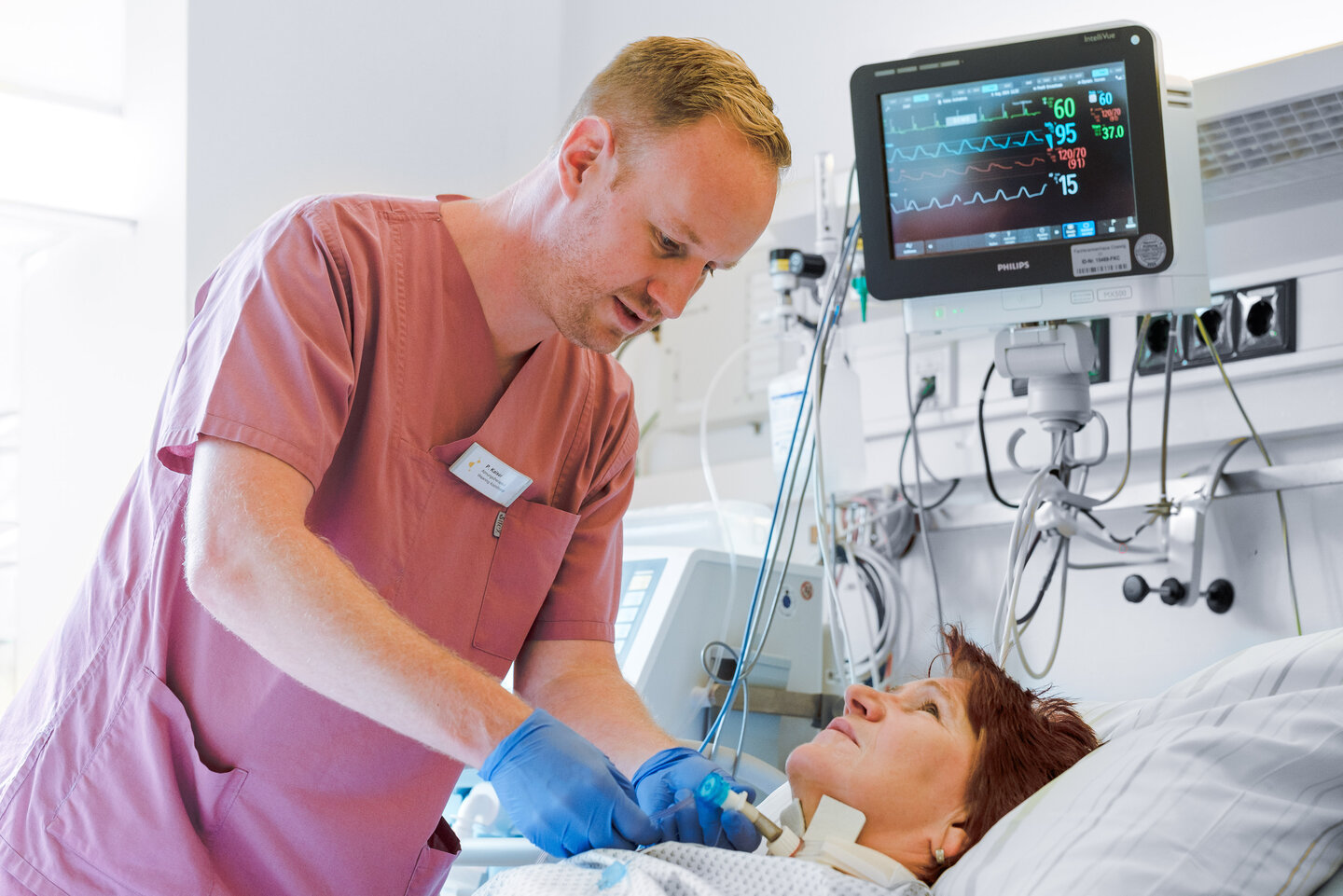 Pflegekraft überwacht die Trachealkanüle bei einer Patientin