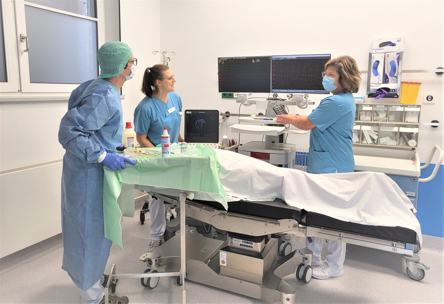 Medizinisches Personal bei der Herzkathetermessung eines Patienten.