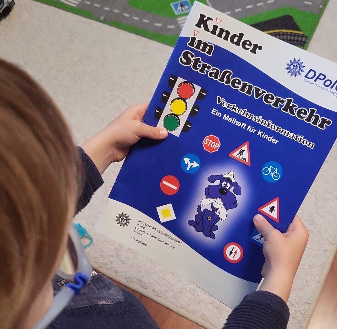 Ein Kind hält das Malbuch in der Hand.